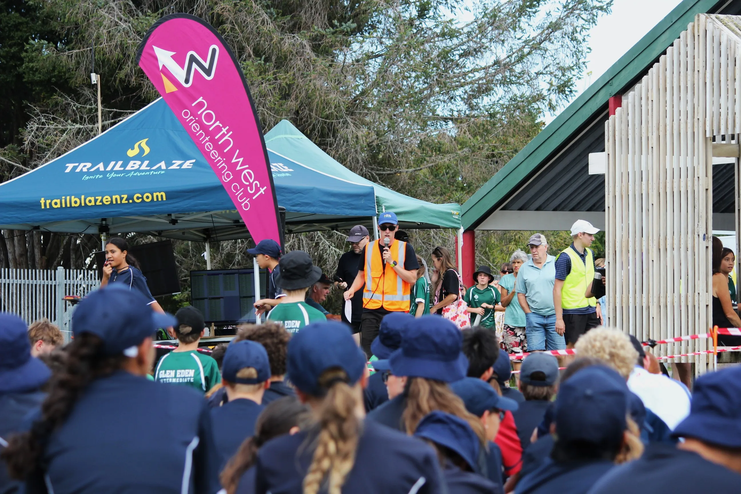 Race briefing in front of a packed field of students, TrailBlaze tent behind